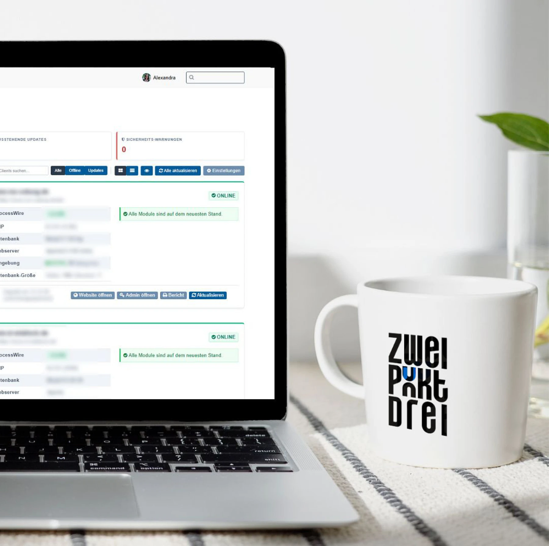 Ein moderner Laptop zeigt das Statusdashboard von Kundenwebsite. Daneben steht eine schlichte weiße Kaffeetasse.